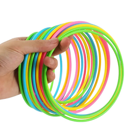 Kids' ring toss game featuring a vibrant tower with rainbow colors and colorful plastic rings.
